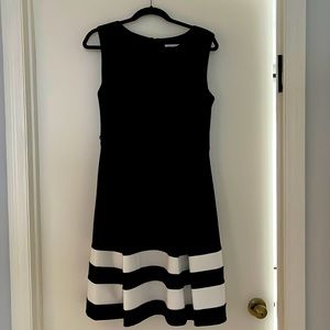 Medium Calvin Klein black dress with black and white stripe detail at bottom.